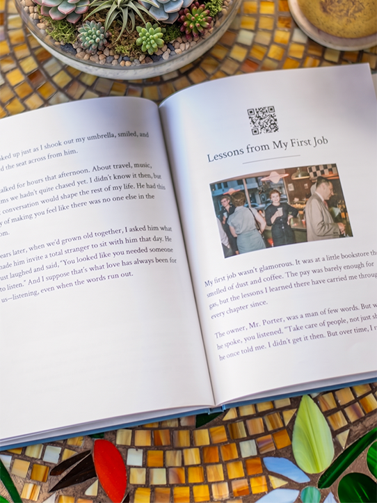 Reminiscely keepsake book open on a table, showing printed stories with QR code visible